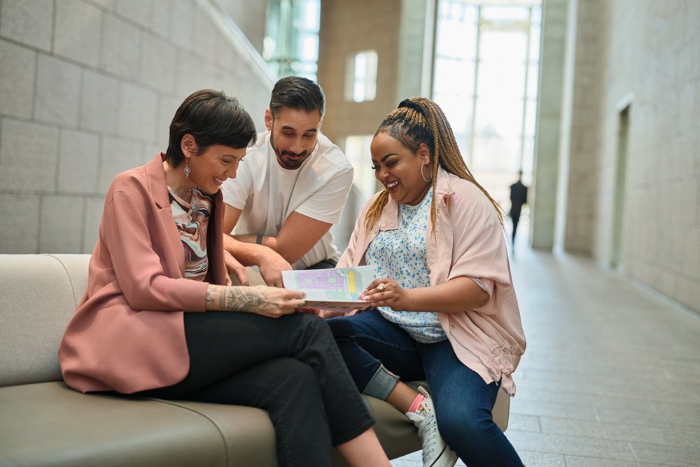Three adults looking at a map together.