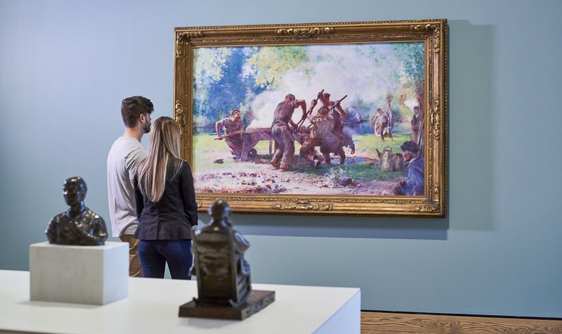 Two visitors viewing an artwork in the Indigenous and Canadian galleries.